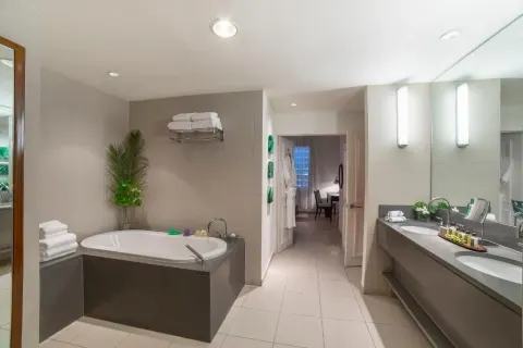Beach balcony suite bathroom at Carlisle Bay with soaking tub, double vanity and towels.