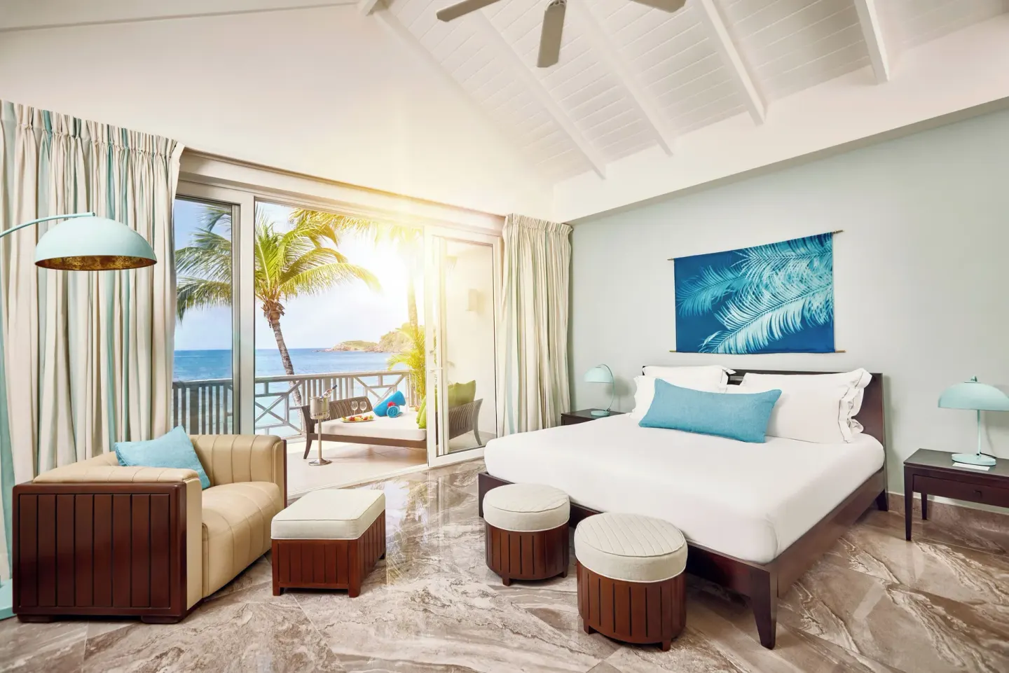 Carlisle Bay suite bedroom with a king bed, vaulted ceiling and ocean-view balcony.