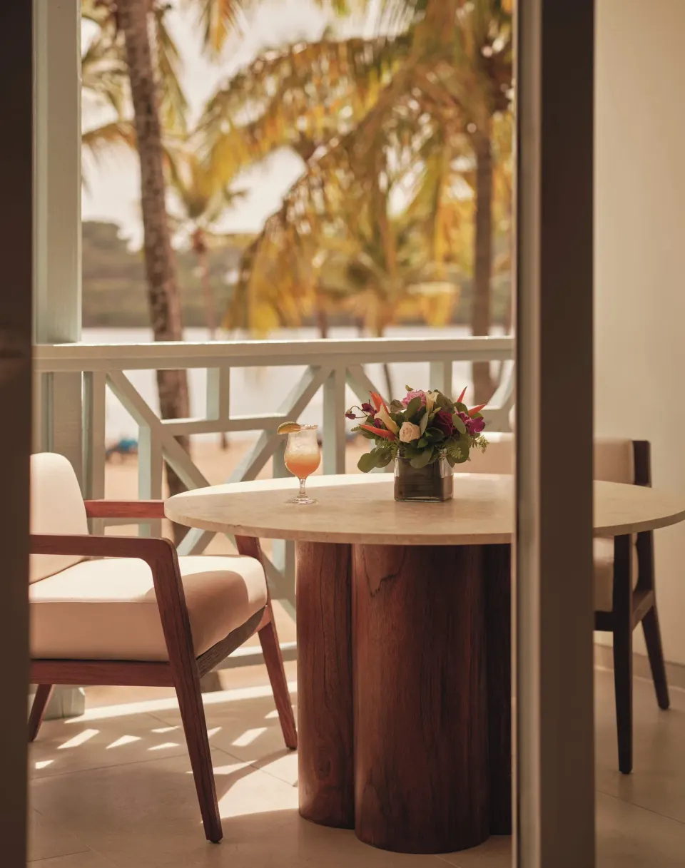Ocean Suite balcony dining table with palms beyond at Carlisle Bay.