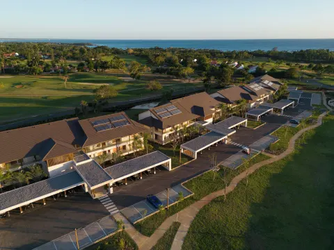 Aerial view of resort buildings, golf greens, and ocean at Casa de Campo Resort and Villas and Villas and Villas.