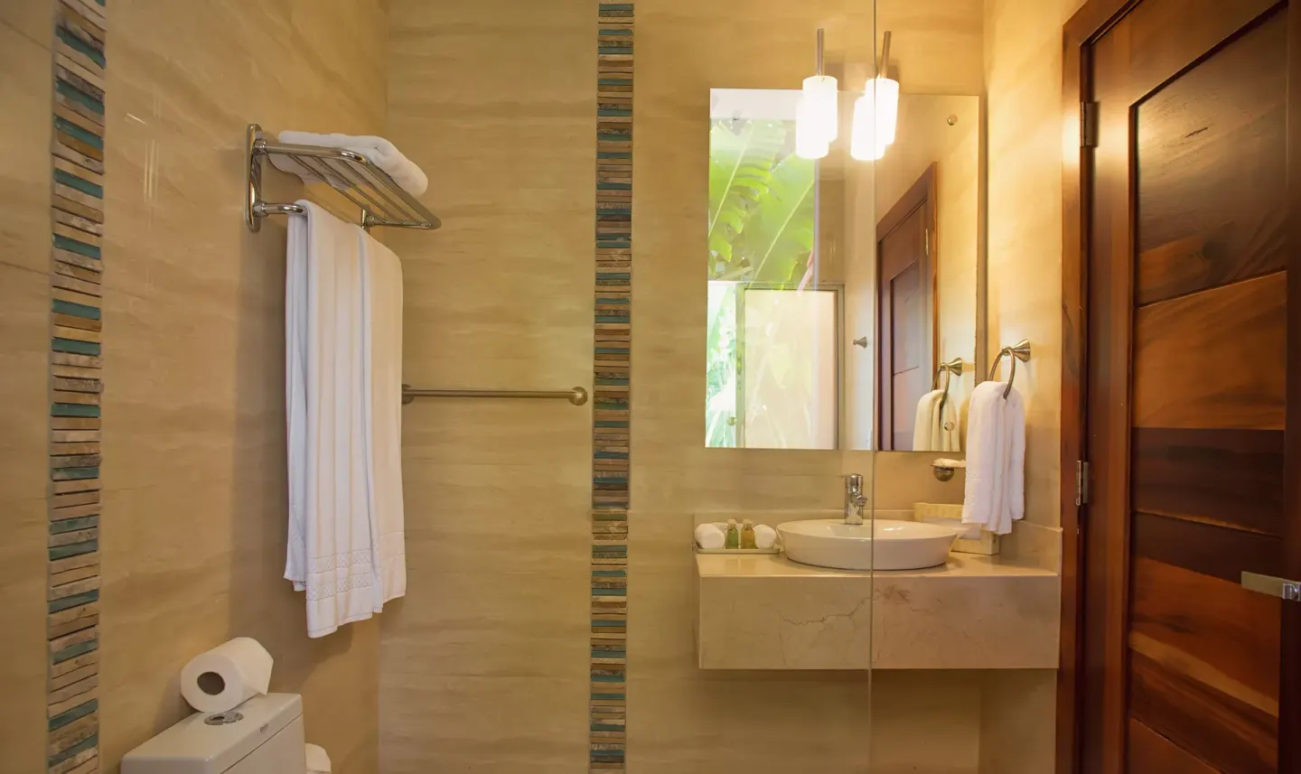 Bathroom vanity with glass partition and striped tile accents at Casa de Campo Resort and Villas and Villas and Villas.