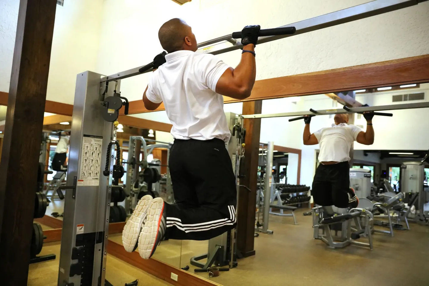 Guest using a pull-up machine in the fitness center at Casa de Campo Resort and Villas and Villas and Villas.