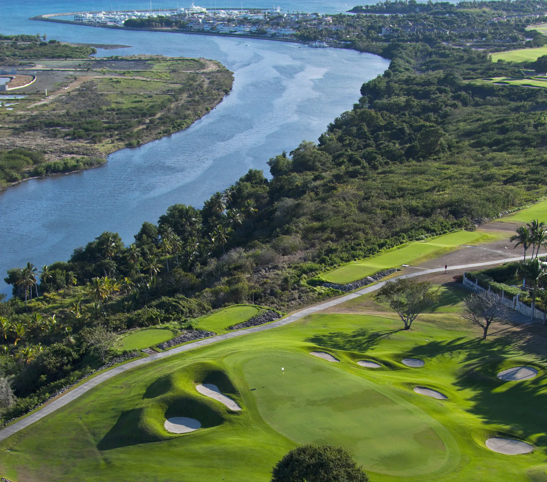 Golf course green and bunkers near a waterway at Casa de Campo Resort and Villas.