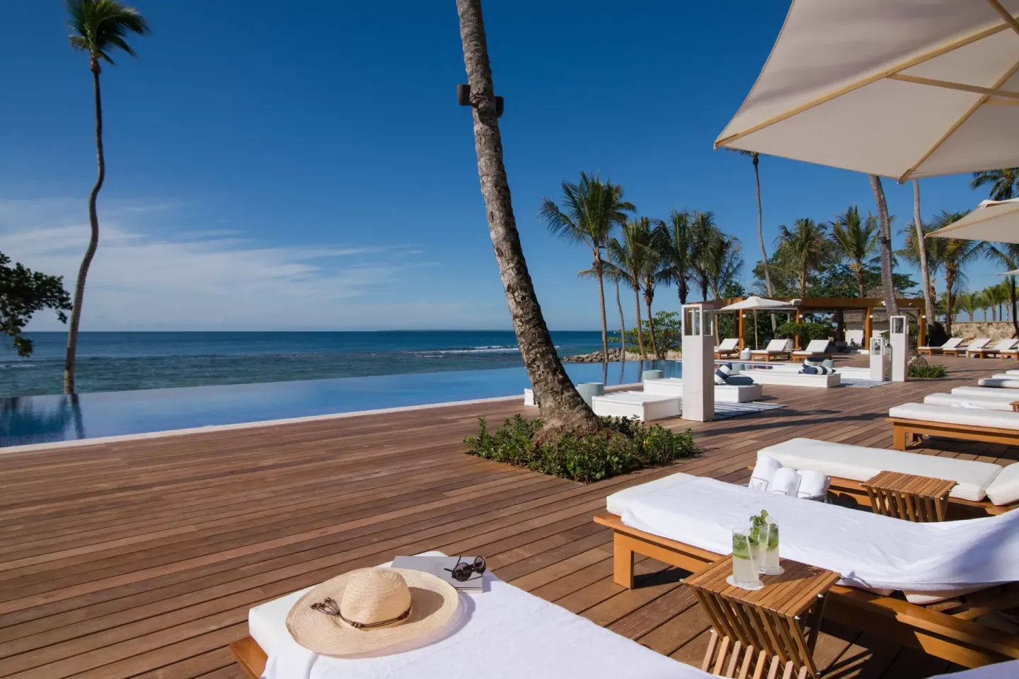 Oceanfront pool deck with loungers and umbrellas at Casa de Campo Resort and Villas and Villas and Villas.