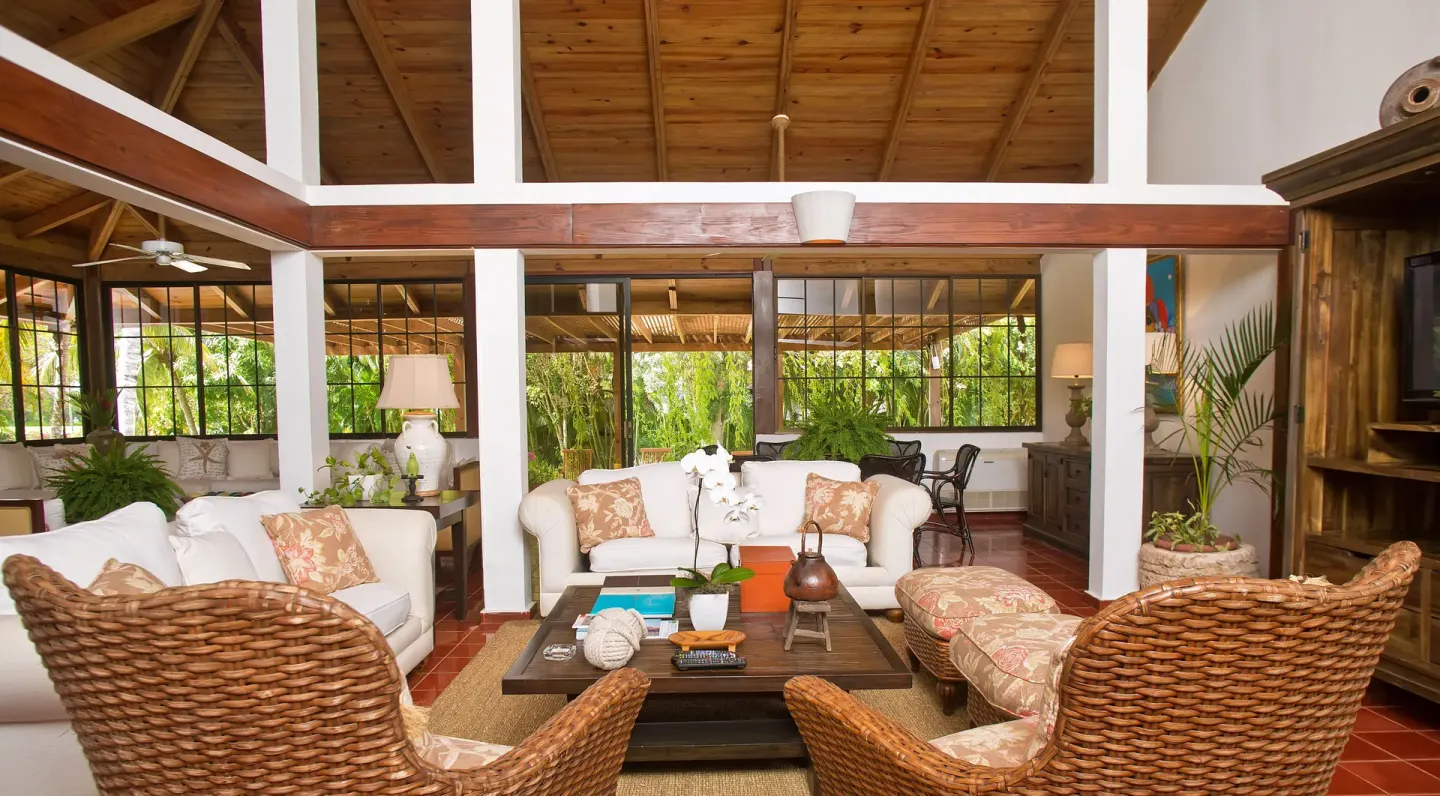 Open villa living area with wicker chairs and garden-facing windows at Casa de Campo Resort and Villas and Villas and Villas.