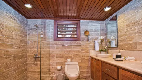 Stone-tiled bathroom with glass shower at Casa de Campo Resort and Villas.