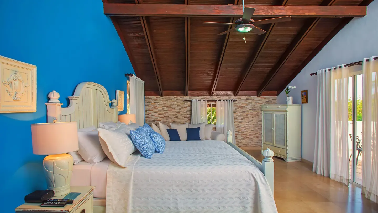 Bedroom with a white bed and blue accent wall at Casa de Campo Resort and Villas and Villas and Villas.