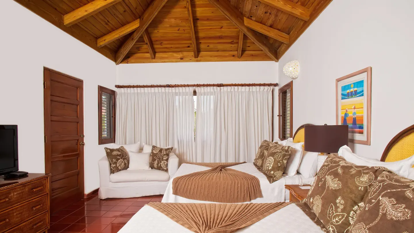 Bedroom with two beds and a vaulted wood ceiling at Casa de Campo Resort and Villas and Villas and Villas.