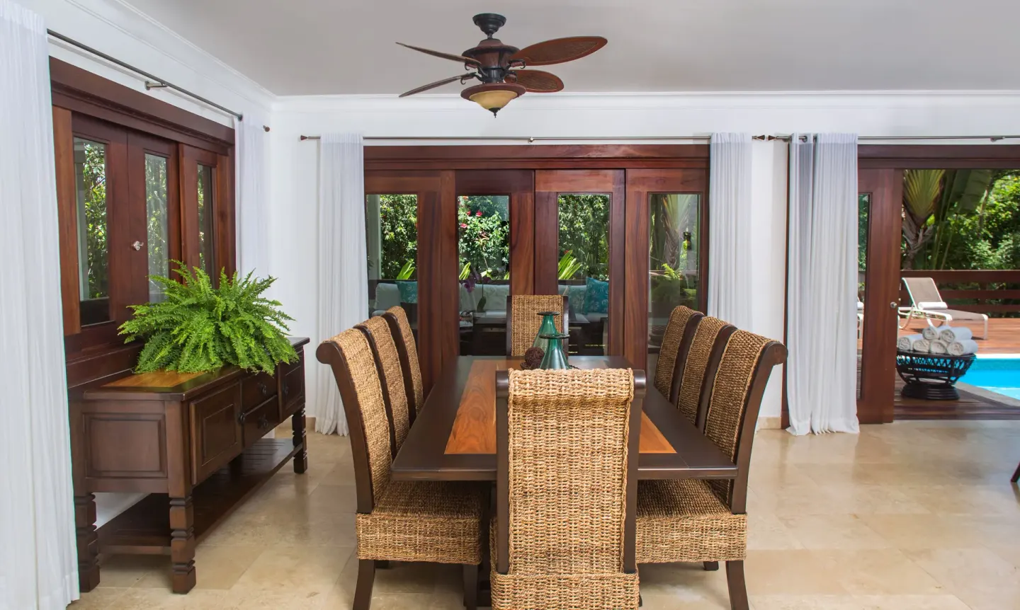 Villa dining area with long table and pool beyond at Casa de Campo Resort and Villas and Villas and Villas.