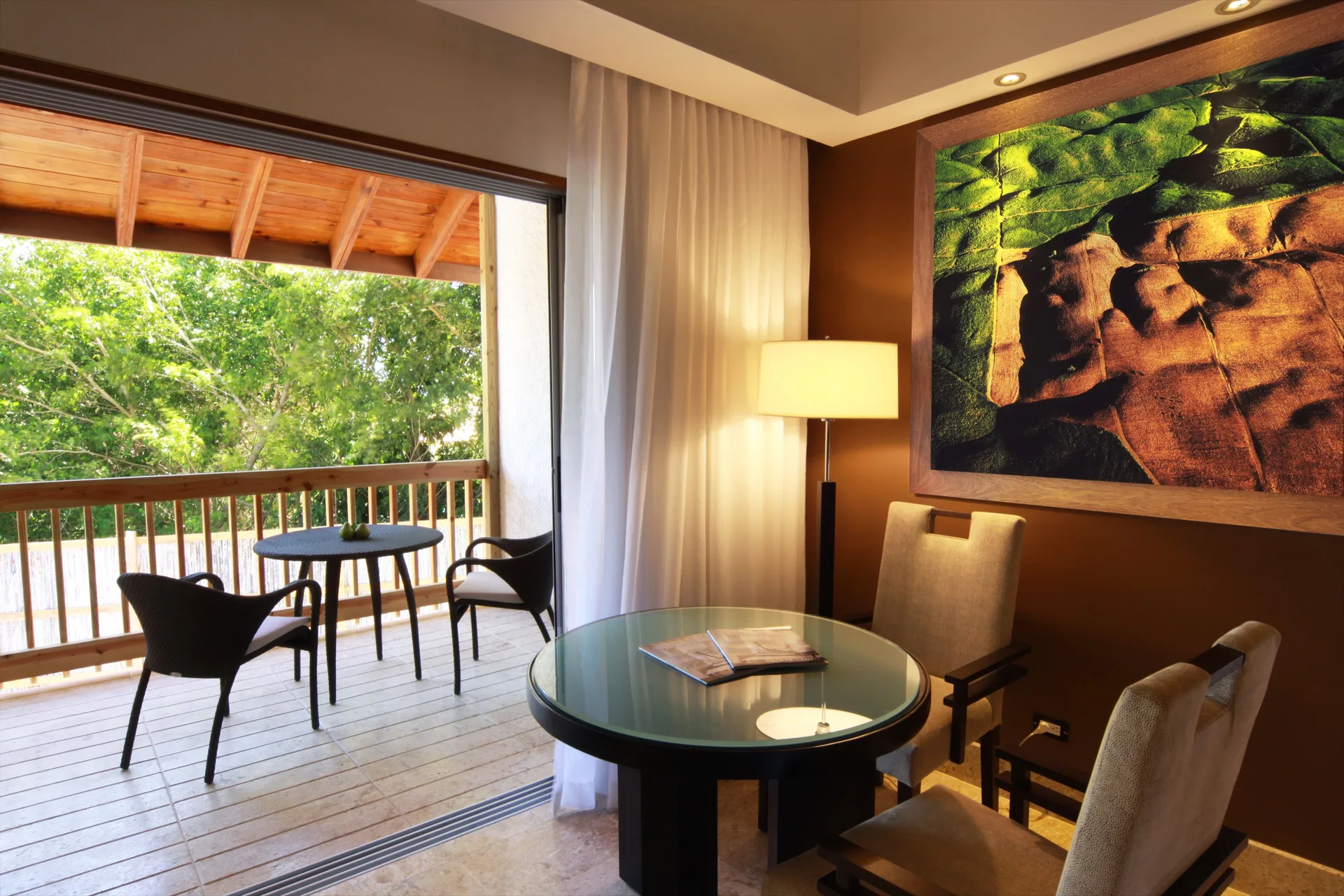 Elite Room balcony dining area with tree views at Casa de Campo Resort and Villas.