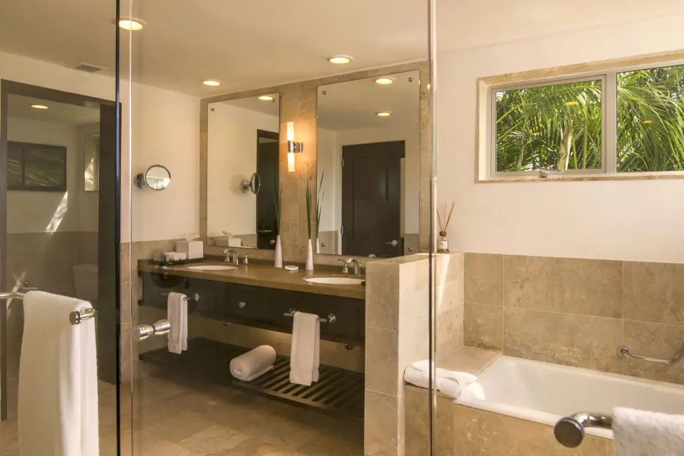 Elite Room bathroom with soaking tub, glass partition, and double vanity at Casa de Campo Resort and Villas and Villas and Villas.