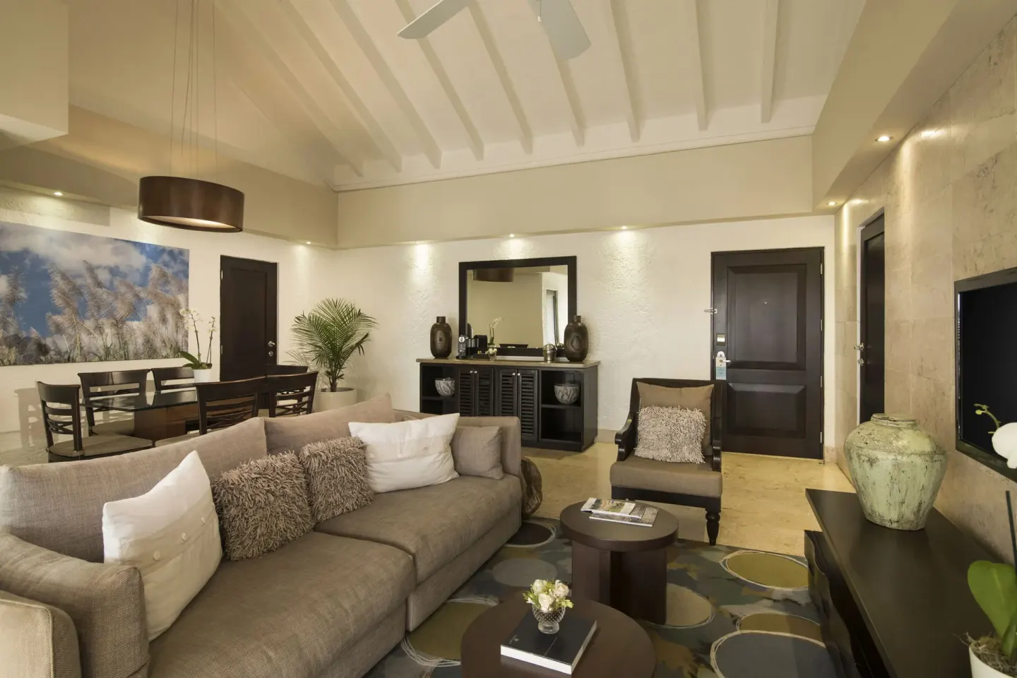 Elite Suite living and dining area at Casa de Campo Resort and Villas with sofa, table, and TV.