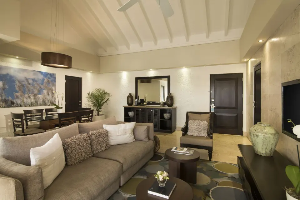 Elite Suite living and dining area at Casa de Campo Resort and Villas with sofa, table, and TV.