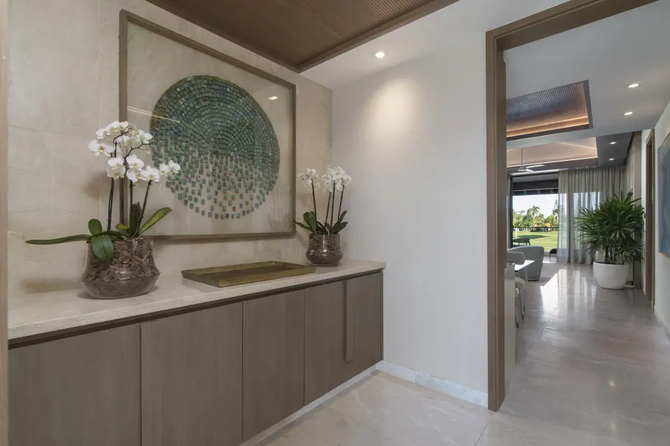 Entry foyer of a One Bedroom Luxury Premier Suite at Casa de Campo Resort and Villas and Villas and Villas with orchids and artwork.