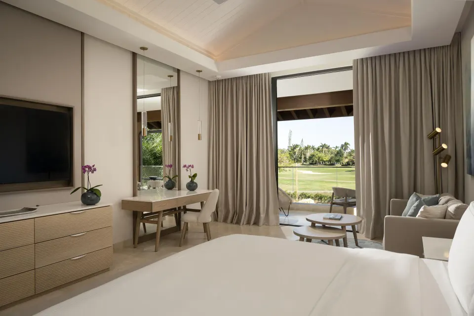One Bedroom Luxury Premier Suite king bed and sitting area at Casa de Campo Resort and Villas.