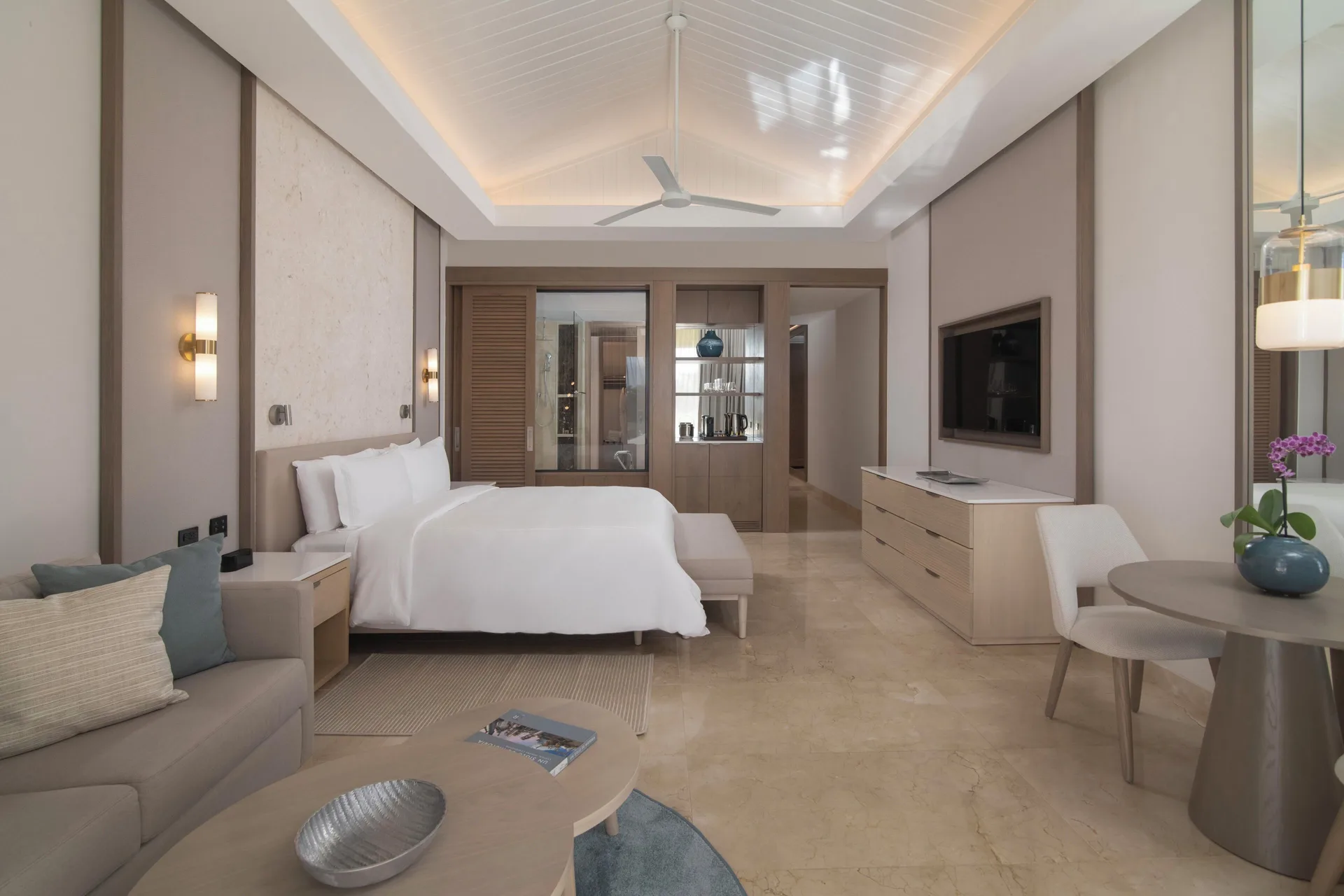 Premier Jr. Suite with Balcony king bed and sitting area at Casa de Campo Resort and Villas with tropical views from private balcony.