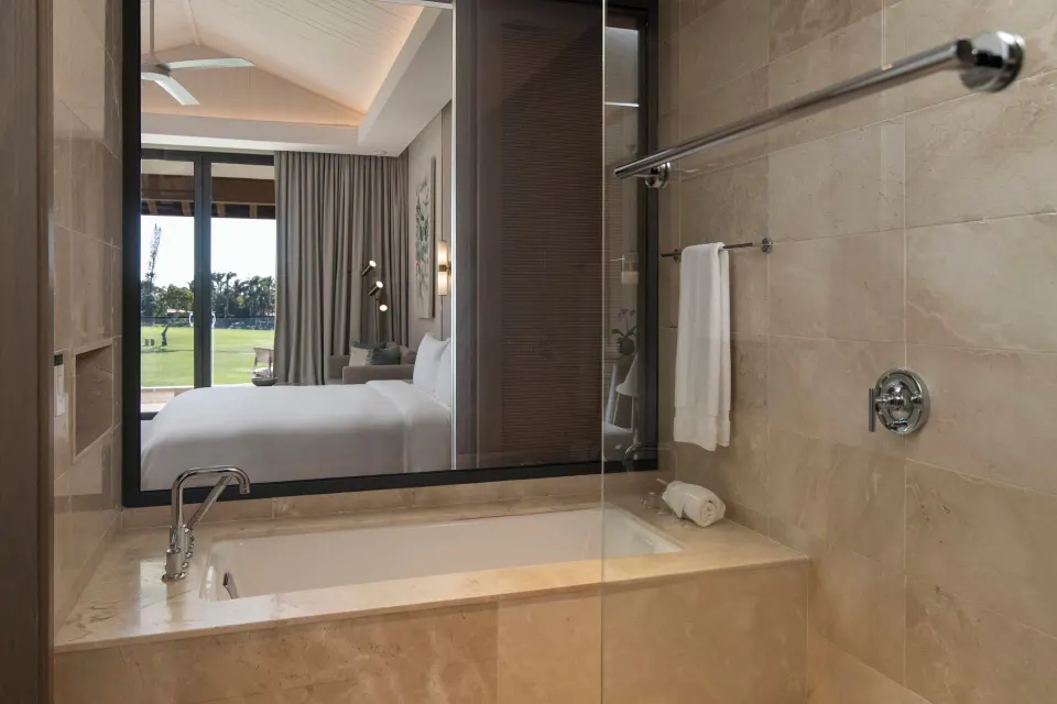 Marble bathroom with tub and glass shower in a suite at Casa de Campo Resort and Villas.
