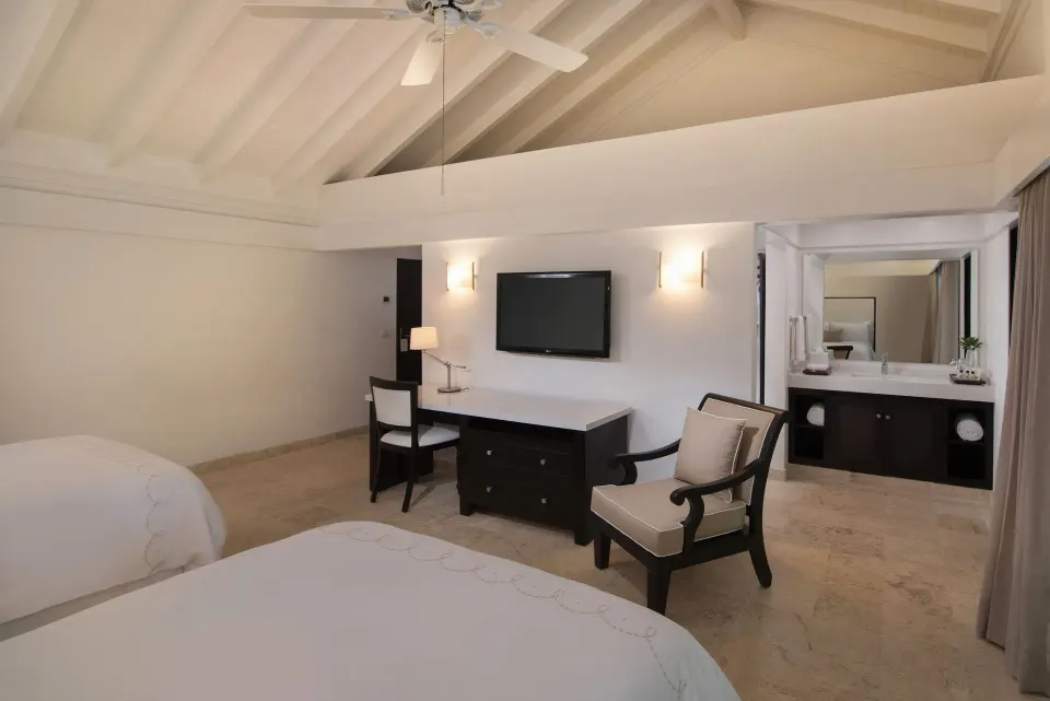 Superior Casita double-bed room at Casa de Campo Resort and Villas with vanity visible beyond the bedroom.