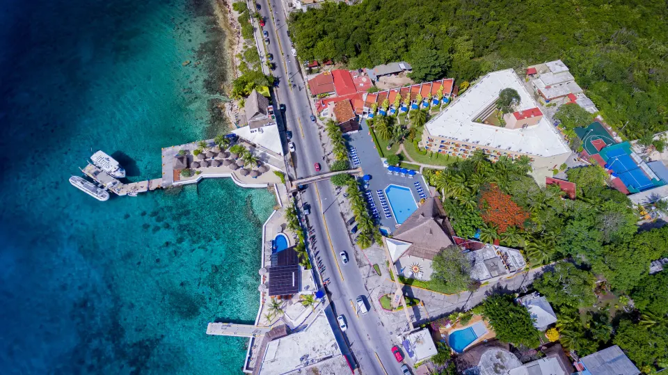 Aerial view of Casa del Mar Cozumel Hotel & Dive Resort showing docks, pool and coastline.