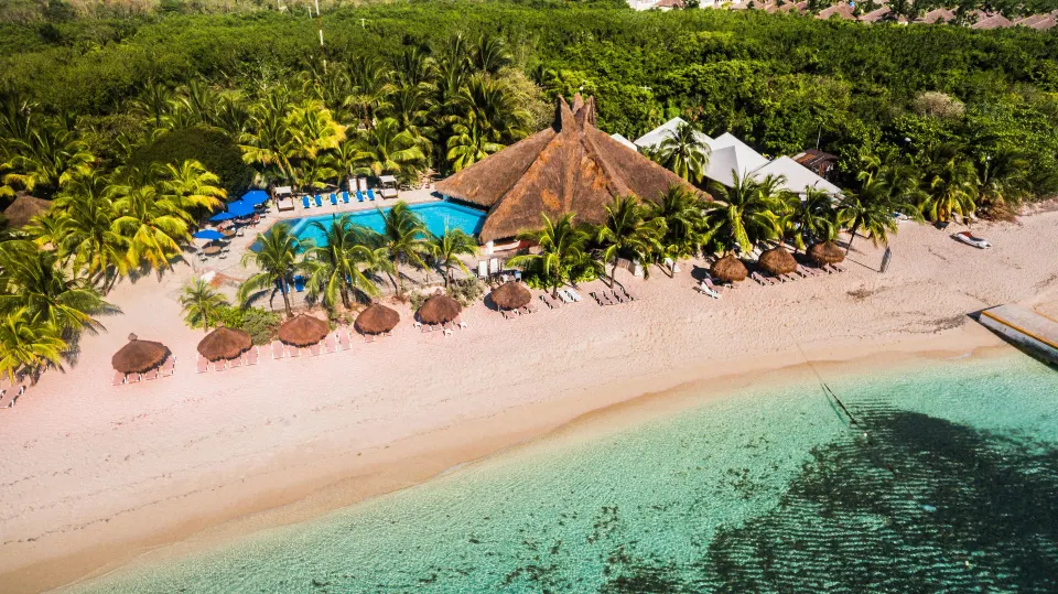 Aerial view of the sandy beach, palapas and ocean frontage at Casa del Mar Cozumel Hotel & Dive Resort