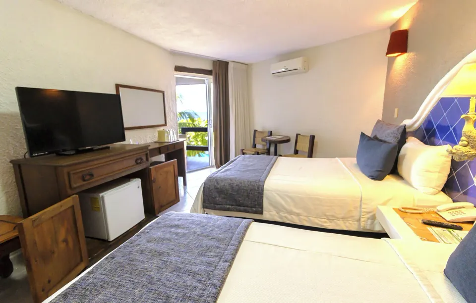 Guest room with two beds, TV and balcony at Casa del Mar Cozumel Hotel & Dive Resort