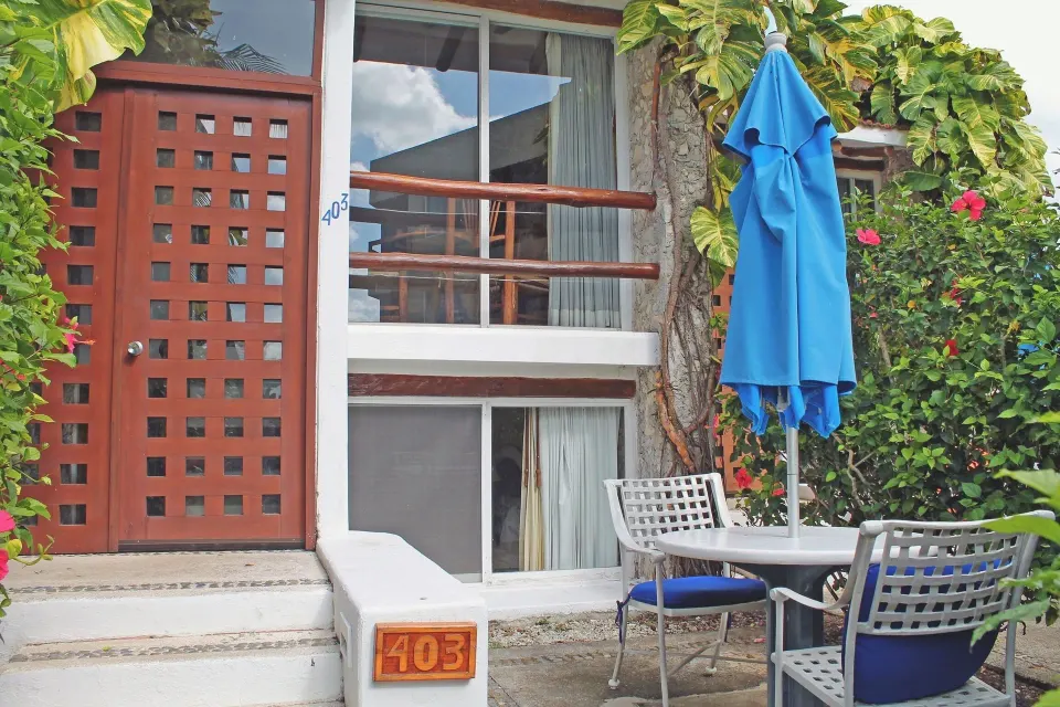 Ground-floor room entrance with table and umbrella outside at Casa del Mar Cozumel Hotel & Dive Resort