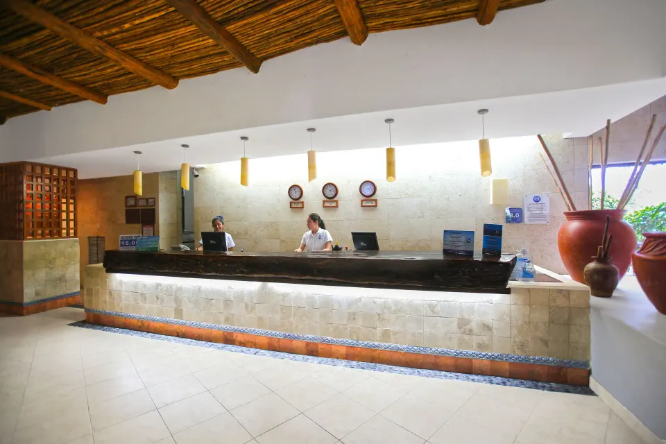 Reception counter lit from below with pendant lights at Casa del Mar Cozumel Hotel & Dive Resort.