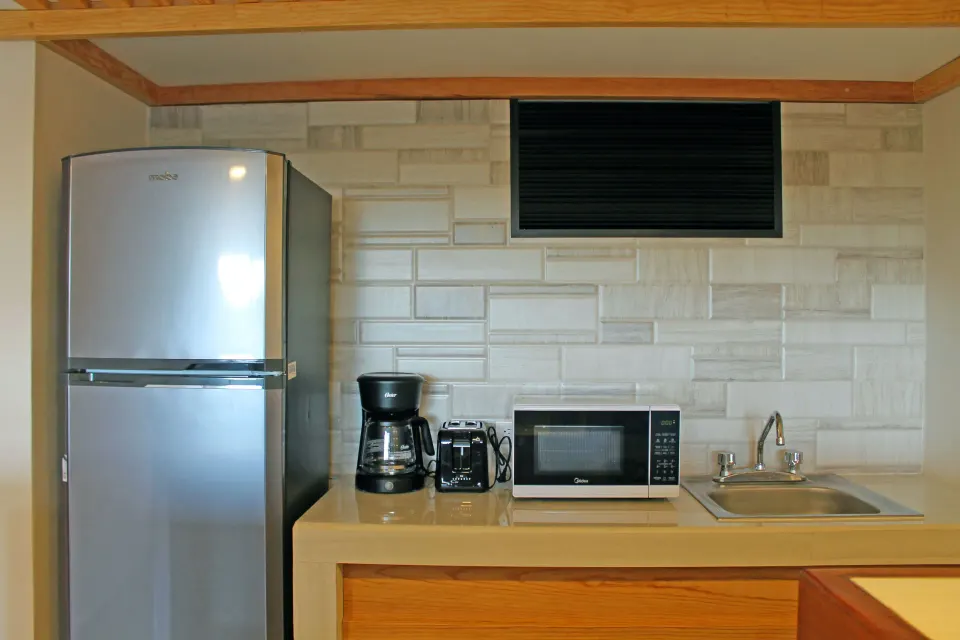 Close-up of kitchenette with refrigerator, coffee maker and microwave at Casa del Mar Cozumel Hotel & Dive Resort
