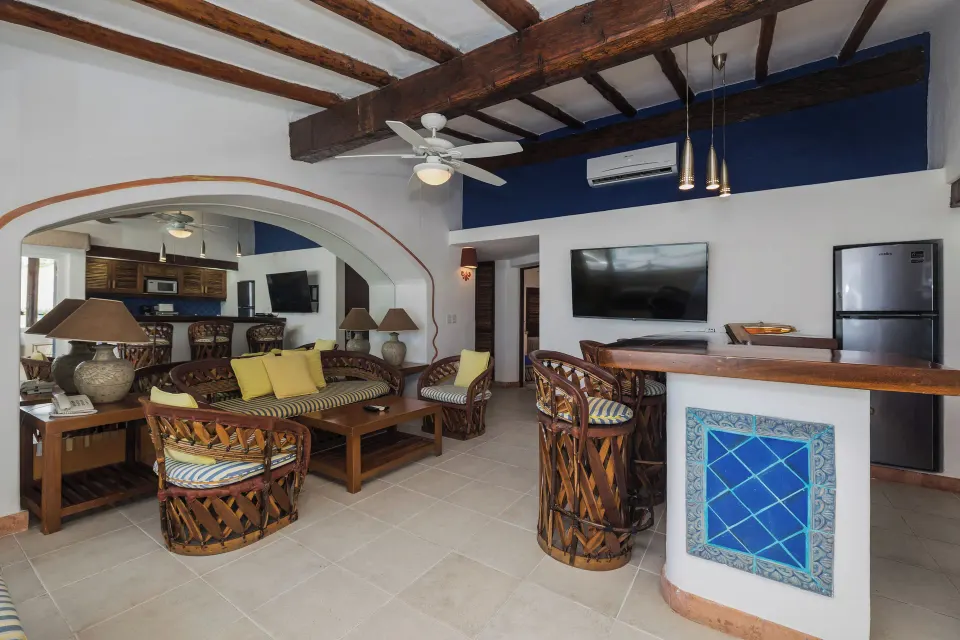 Open-plan living room with breakfast bar, TV and refrigerator at Casa del Mar Cozumel Hotel & Dive Resort