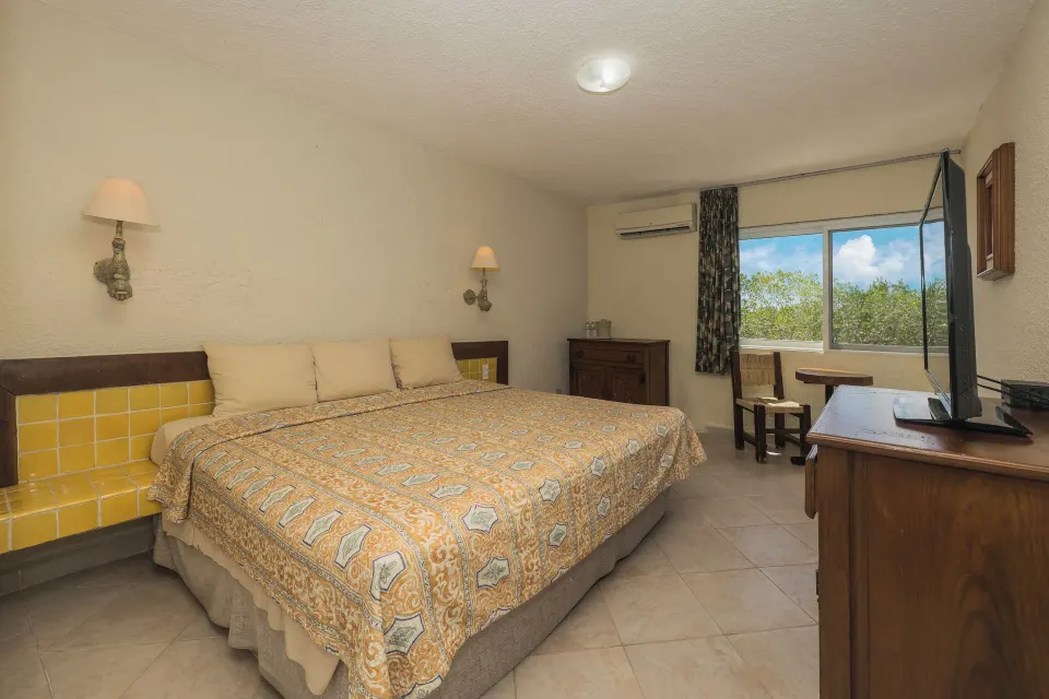 Guest room with king bed, desk and window at Casa del Mar Cozumel Hotel & Dive Resort