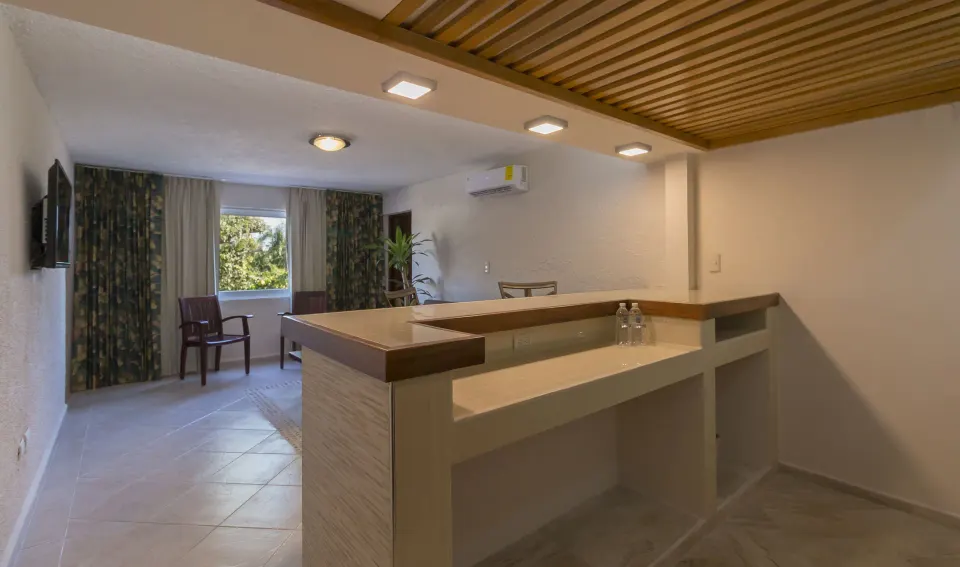 Suite living space with raised bar counter and window at Casa del Mar Cozumel Hotel & Dive Resort