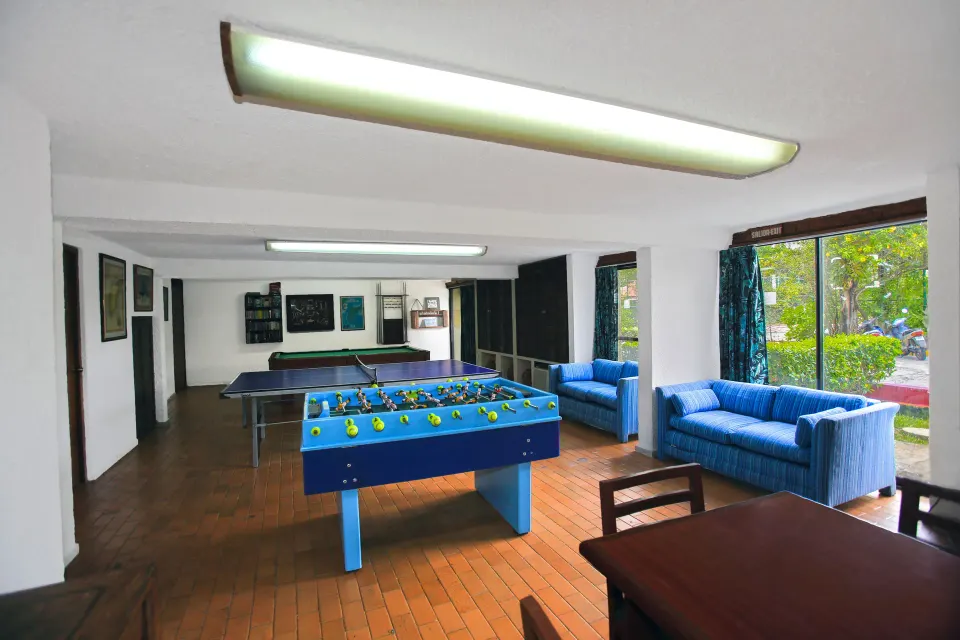 Wide view of the hotel's games room with foosball, seating and large windows at Casa del Mar Cozumel Hotel & Dive Resort