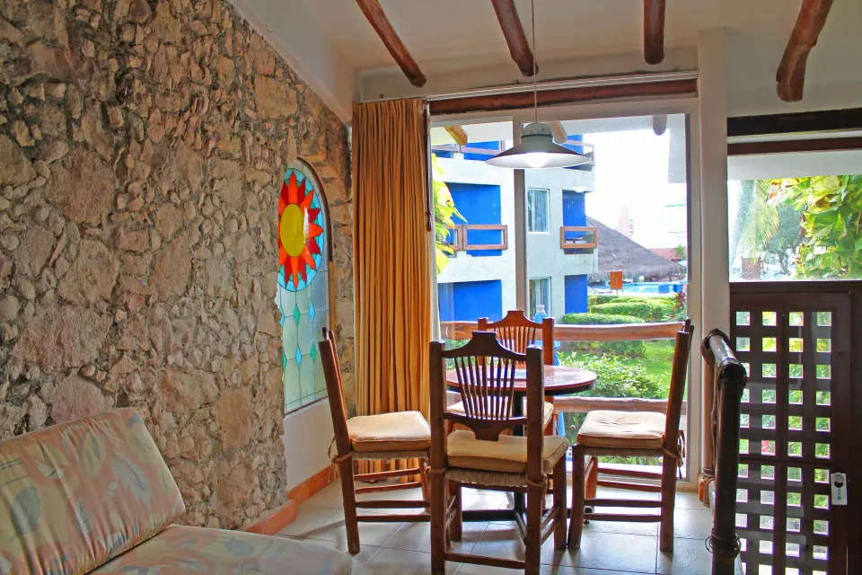 Deluxe cabin seating area with dining table and balcony view at Casa del Mar Cozumel Hotel & Dive Resort