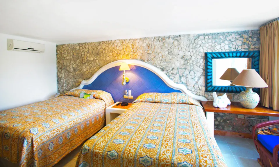 Guest room with two double beds and bedside table at Casa del Mar Cozumel Hotel & Dive Resort
