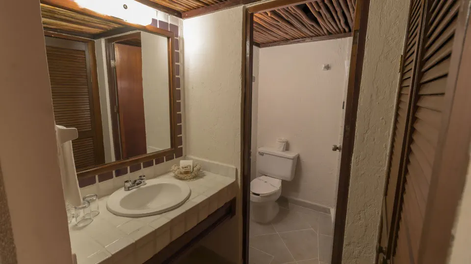 Bathroom vanity and toilet in a connecting room at Casa del Mar Cozumel Hotel & Dive Resort
