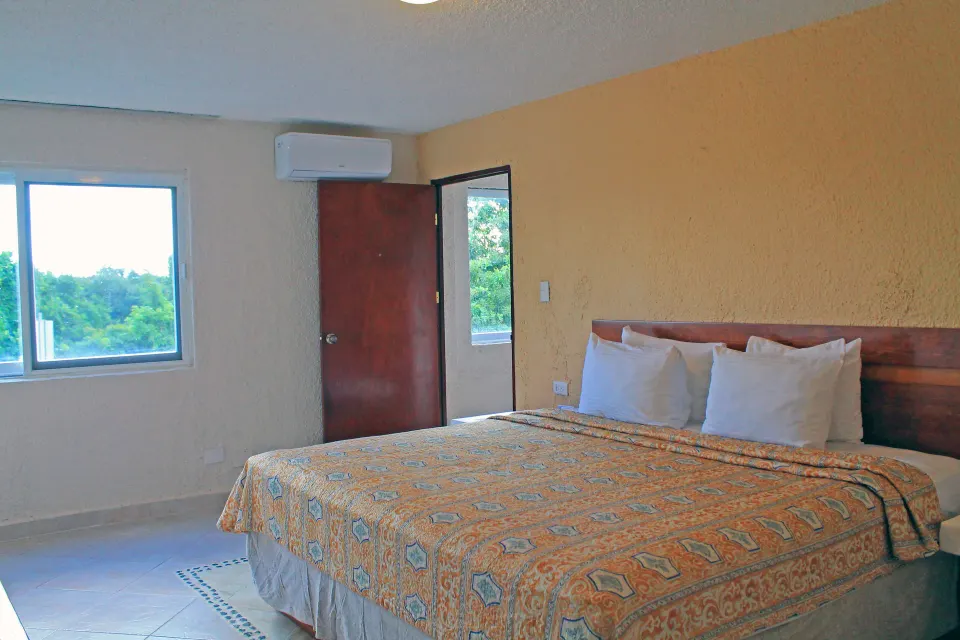 Bedroom with king bed and window at Casa del Mar Cozumel Hotel & Dive Resort