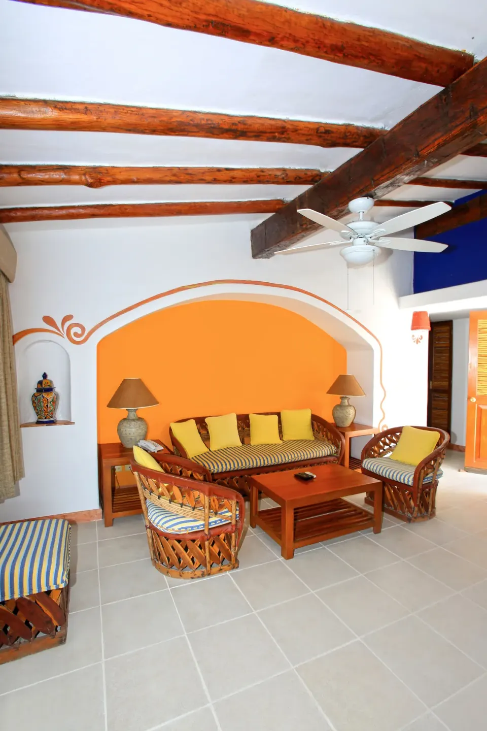 Cozy seating nook with yellow cushions under wooden beams at Casa del Mar Cozumel Hotel & Dive Resort