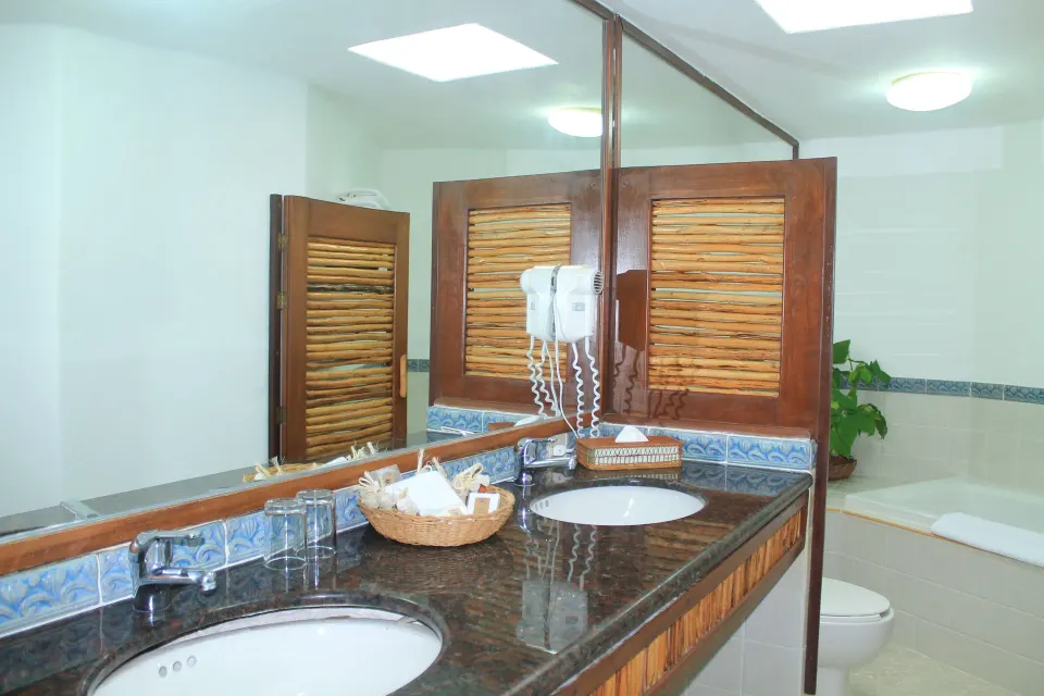 Double-sink bathroom vanity and bathtub in a Family Room at Casa del Mar Cozumel Hotel & Dive Resort