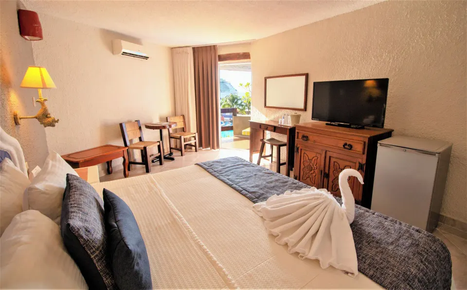 King bed room with towel swan, TV and open balcony at Casa del Mar Cozumel Hotel & Dive Resort