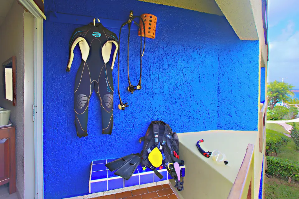 Balcony dive station with wetsuit, fins and partial ocean view at Casa del Mar Cozumel Hotel & Dive Resort