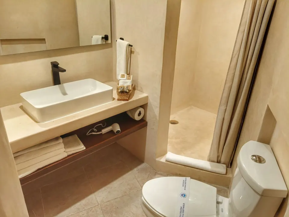 Bathroom sink, shower stall and toilet in a Superior Plus room at Casa del Mar Cozumel Hotel & Dive Resort