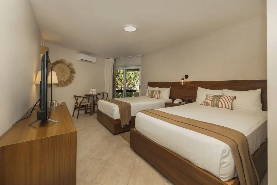 Two double beds and TV in a Superior Plus Garden View room at Casa del Mar Cozumel Hotel & Dive Resort