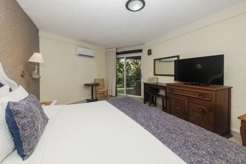Interior view of a Superior Room with two beds and TV at Casa del Mar Cozumel Hotel & Dive Resort