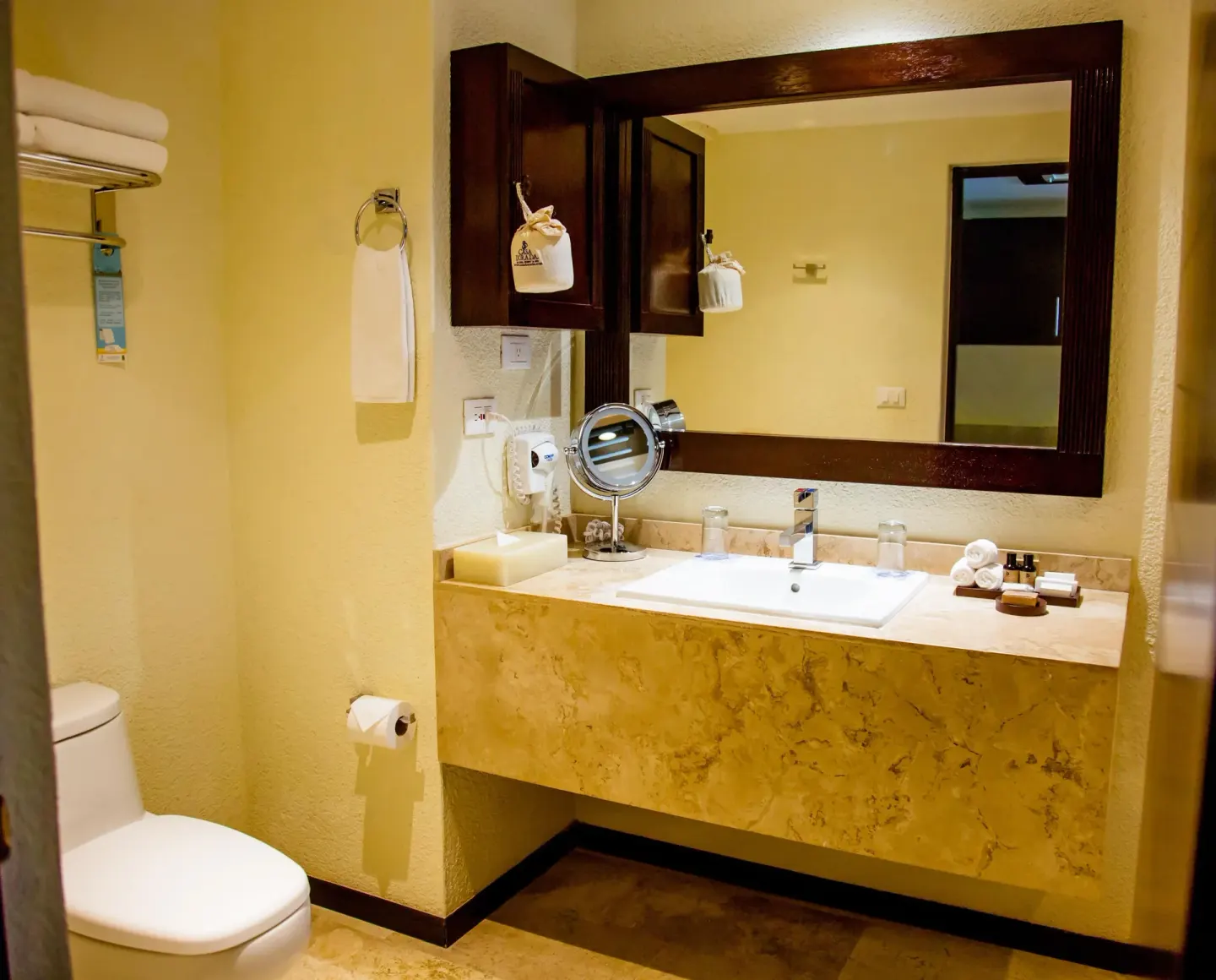 Guest bathroom vanity with mirror and toilet at Casa Dorada Los Cabos Resort & Spa.