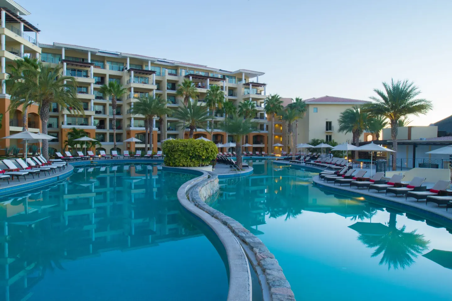 Quiet main pool at dusk with palm reflections at Casa Dorada Los Cabos Resort & Spa.