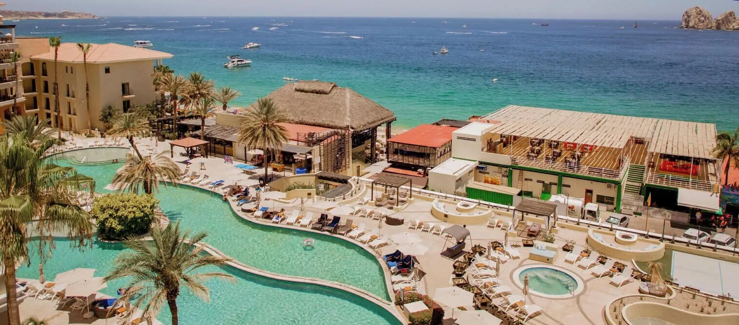 Pool deck and beachfront buildings at Casa Dorada Los Cabos Resort & Spa overlooking the bay.