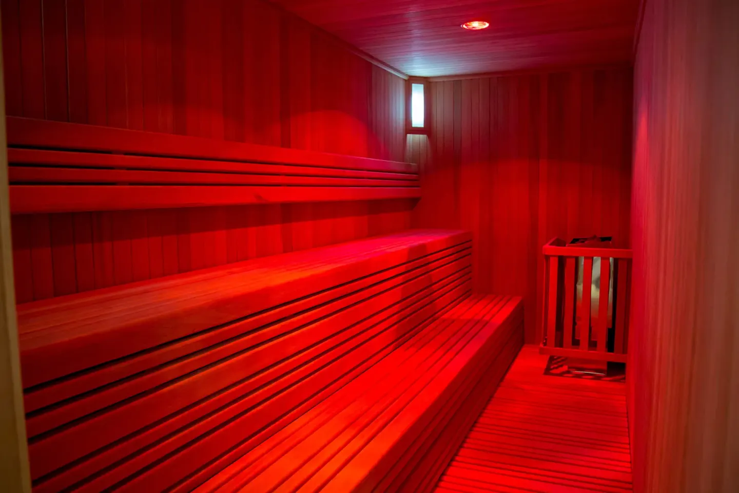 Red-lit wooden sauna with benches at Casa Dorada Los Cabos Resort & Spa.