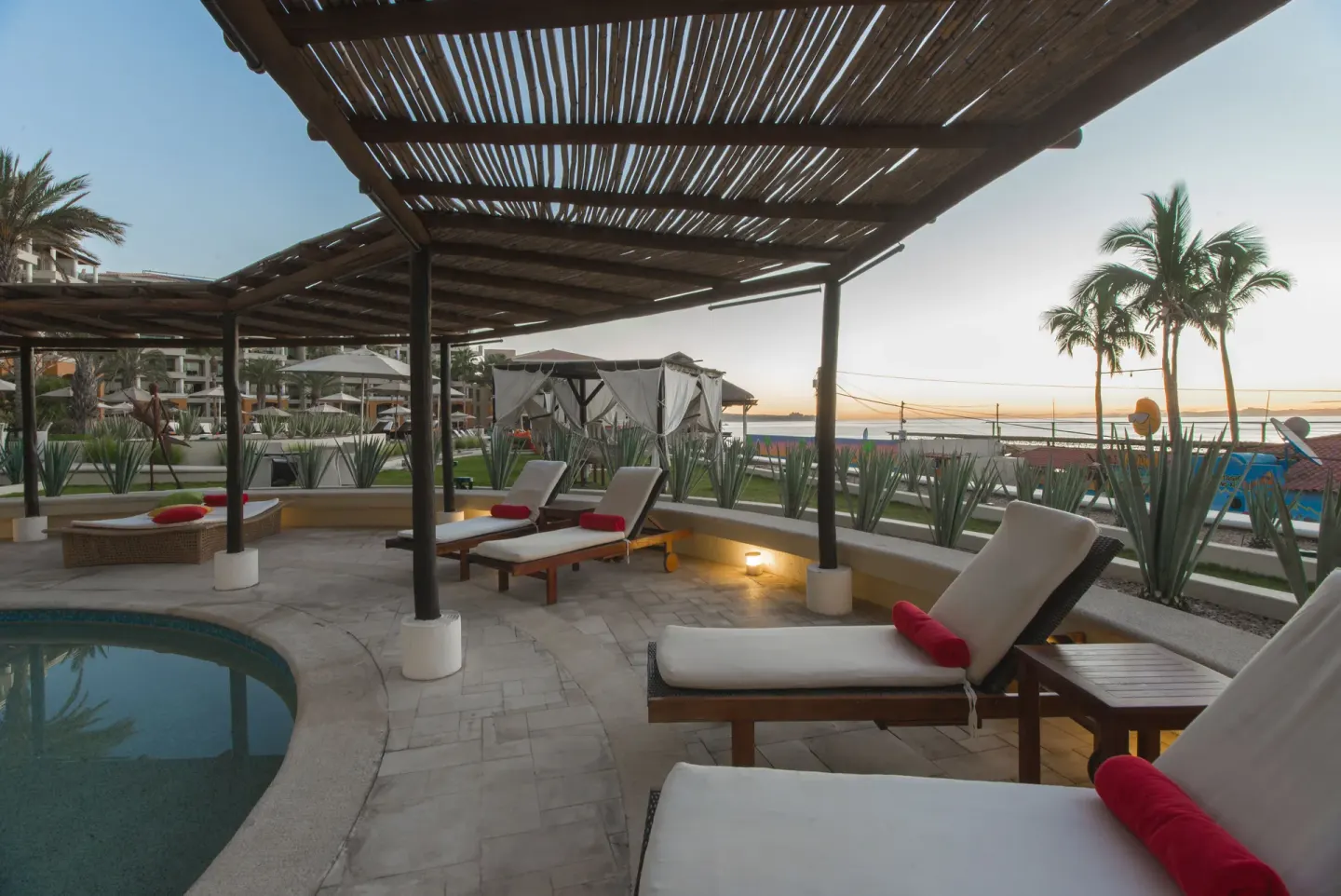 Shaded poolside loungers by the water at Casa Dorada Los Cabos Resort & Spa.