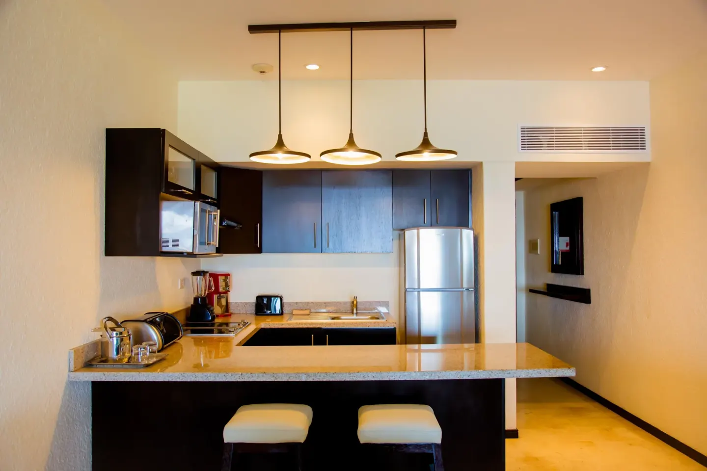 Suite kitchenette with breakfast bar and stools at Casa Dorada Los Cabos Resort & Spa.