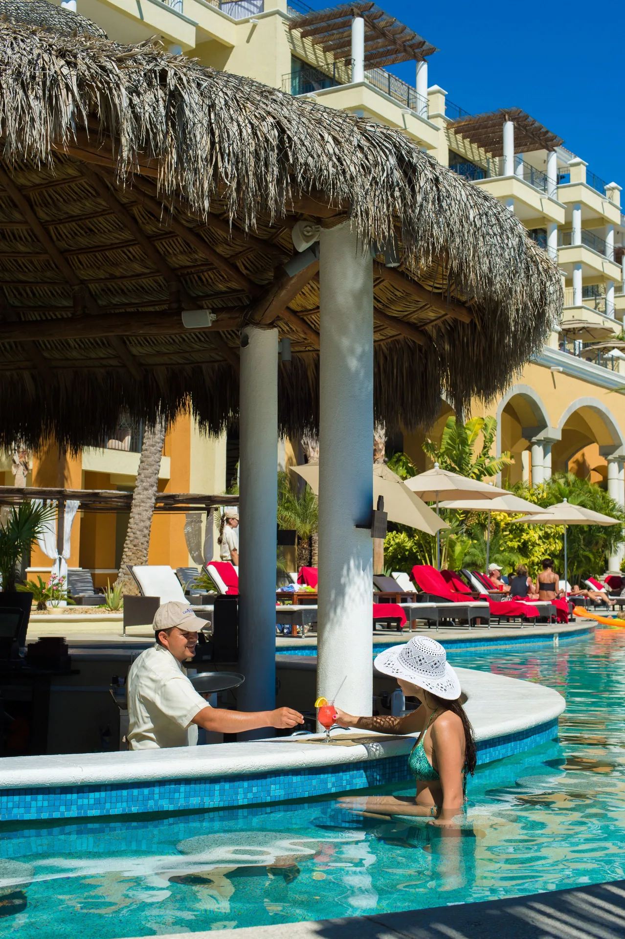 Swim-up pool bar under a thatched roof at Casa Dorada Los Cabos Resort & Spa.
